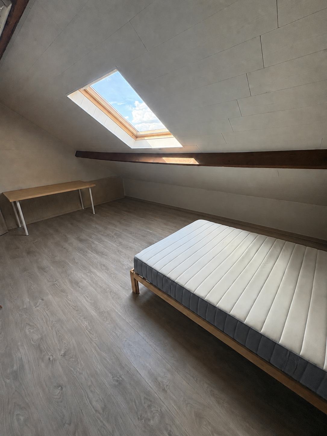 Grande mansardée : le lit sous la fenêtre de toit